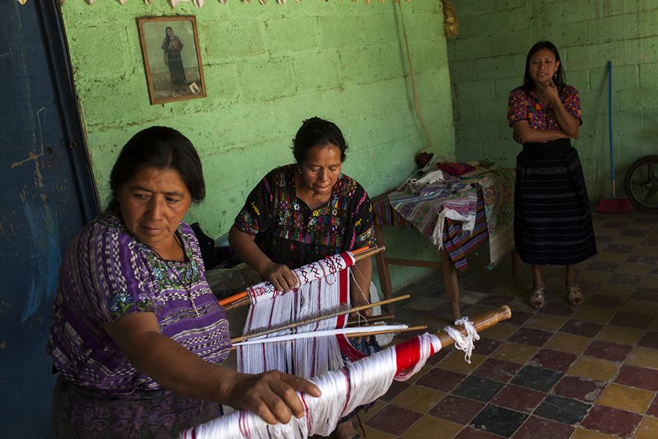 Cristina Boj, 55, and Gloria Estela García, 55, prepare to weave by hand with the typical backstrap loom. Photo: Simone Dalmasso/Plaza Pública